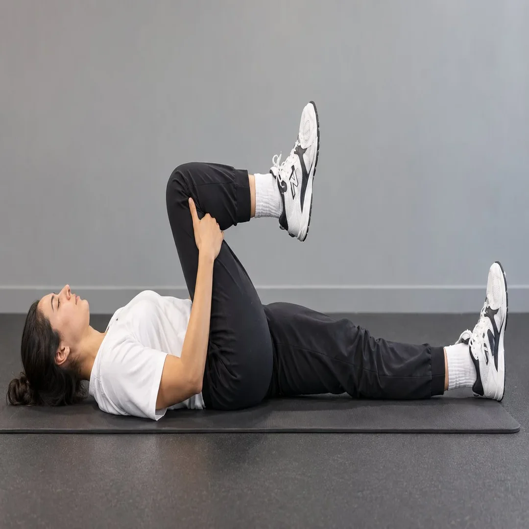 Mujer acostada llevando una rodilla al pecho, ejercicio para la espalda baja